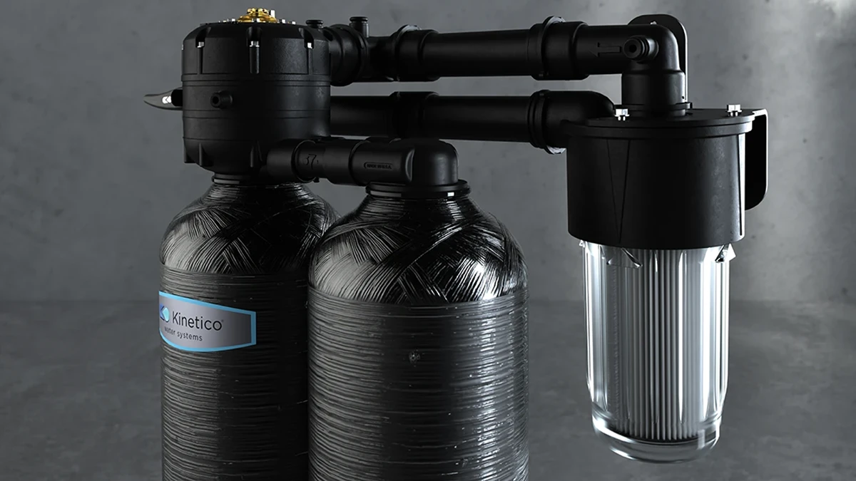 Two black cylindrical water filtration tanks with pipes and a clear, ribbed filter housing on a gray background, labeled "Kinetico Water Systems." Two black cylindrical water filtration tanks with pipes and a clear, ribbed filter housing on a gray background, labeled "Kinetico Water Systems."